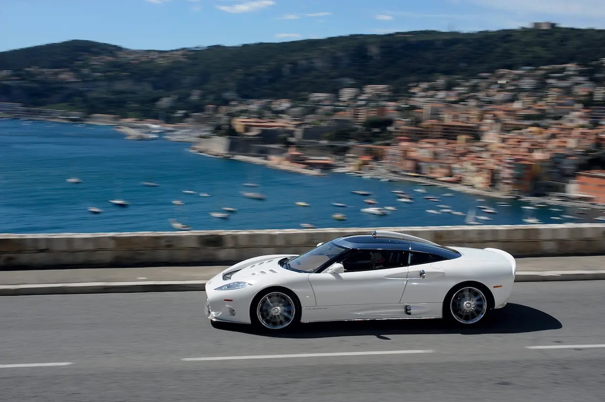 White spyker car with the sea in the background